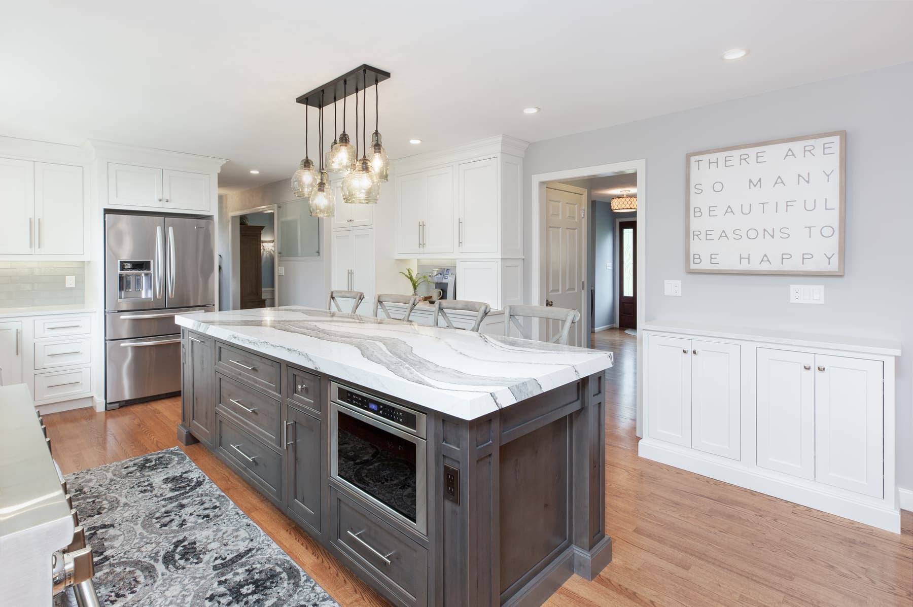 White kitchen cabinetry and a dark island in a Methuen, Massachusetts home