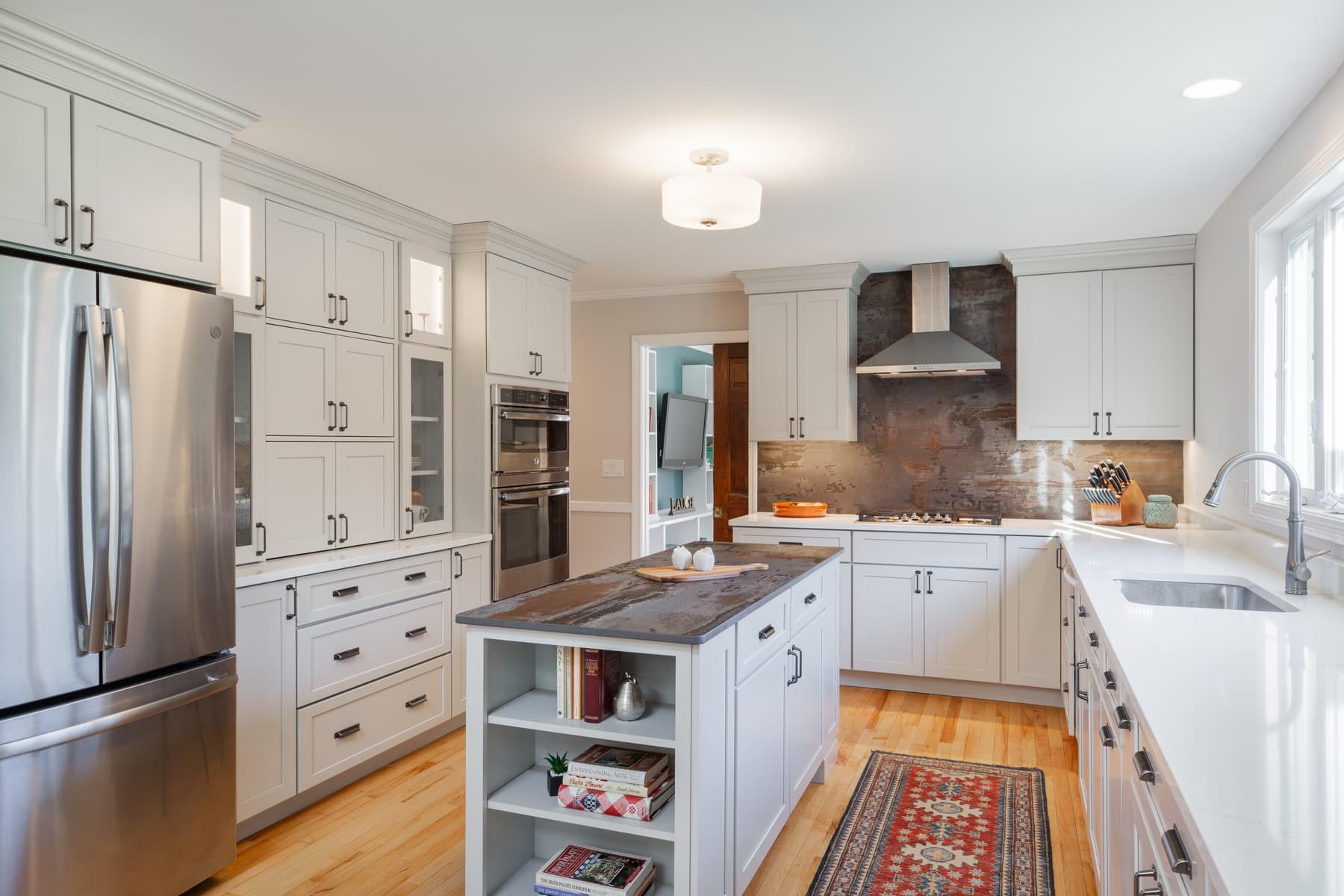 White kitchen cabinetry, quartz counters, and a small island in a Rye, New Hampshire home